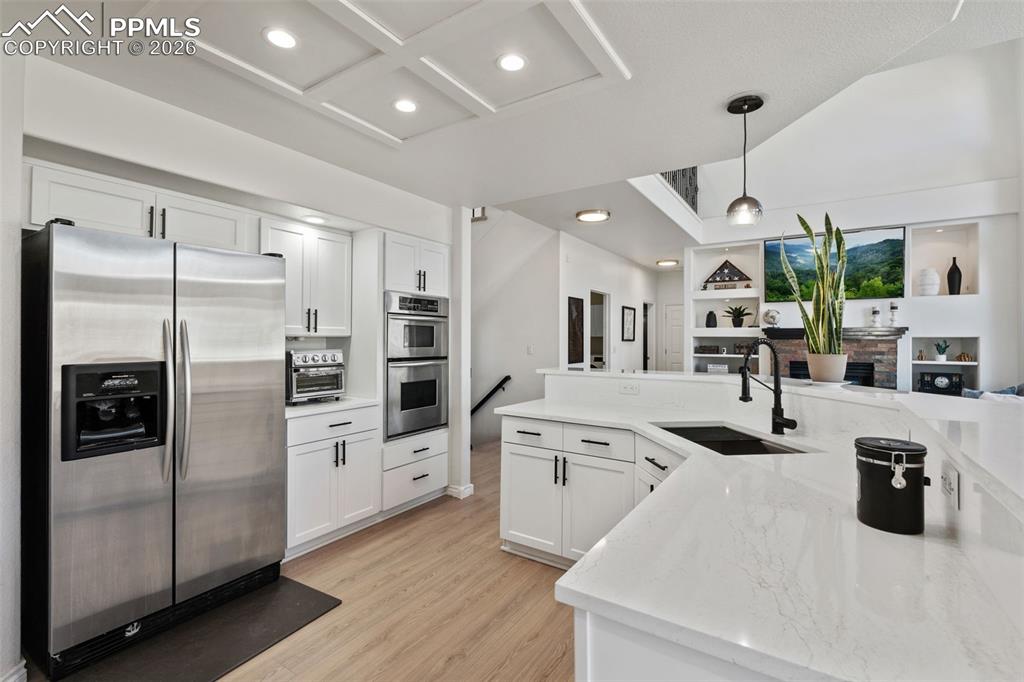 Image 16 of 49: Kitchen featuring stainless steel appliances, white cabinets, open floor pl