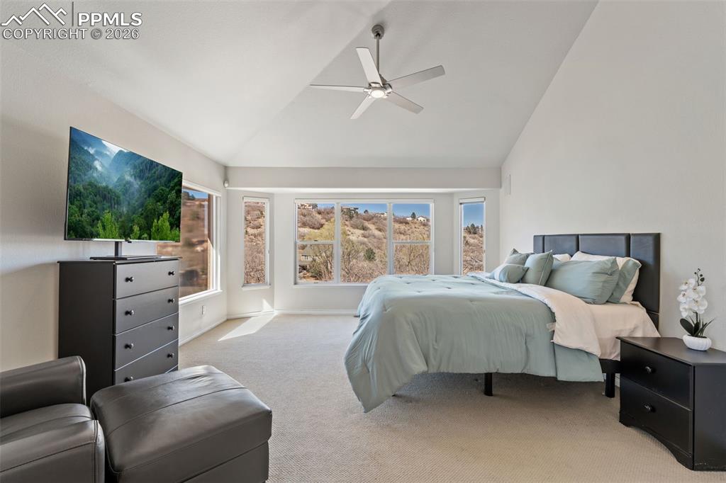 Image 23 of 49: Bedroom with light colored carpet, lofted ceiling, and a ceiling fan