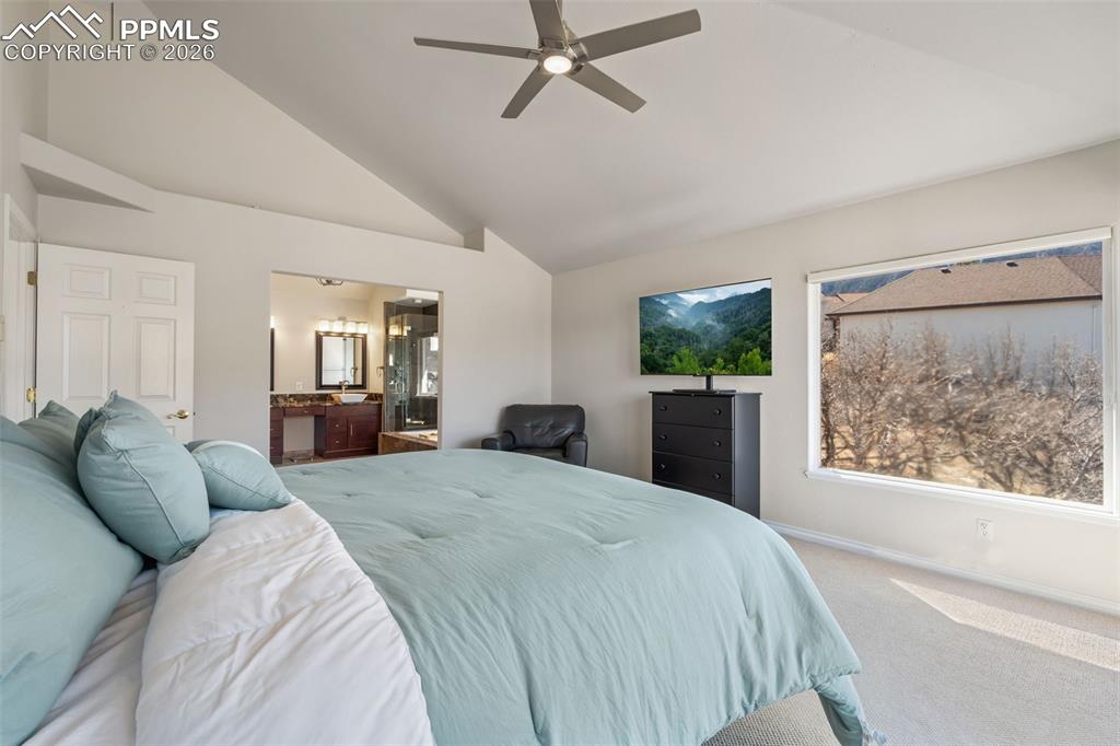 Image 26 of 49: Carpeted bedroom with connected bathroom, lofted ceiling, and a ceiling fan