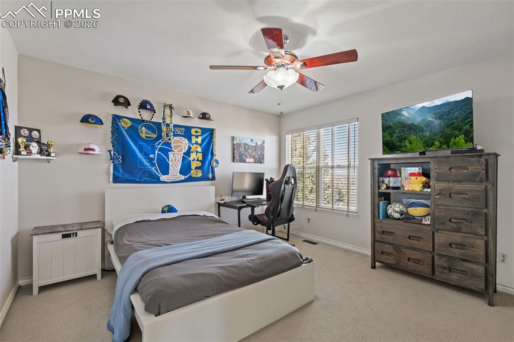 Image 33 of 49: Bedroom with light colored carpet and a ceiling fan