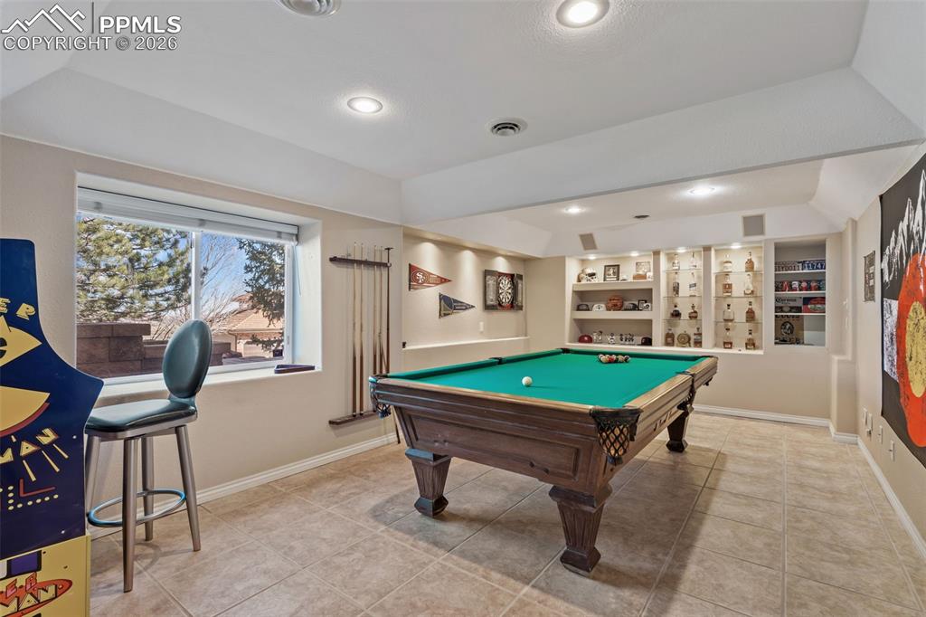 Image 36 of 49: Game room featuring billiards table, built in shelves, light tile patterned