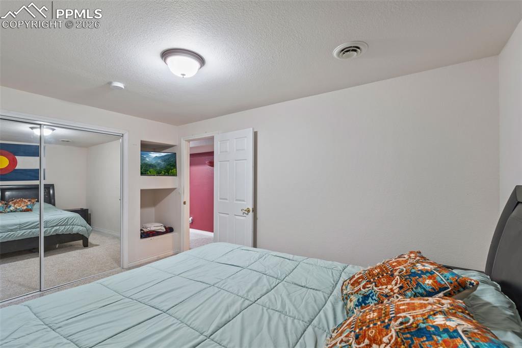 Image 38 of 49: Bedroom with carpet floors, a textured ceiling, and a closet