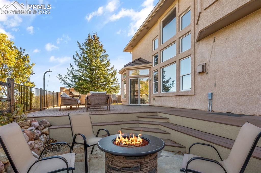 Image 43 of 49: View of patio / terrace featuring a wooden deck and a fire pit
