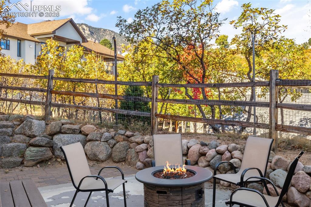 Image 44 of 49: View of patio with an outdoor fire pit and a mountain view