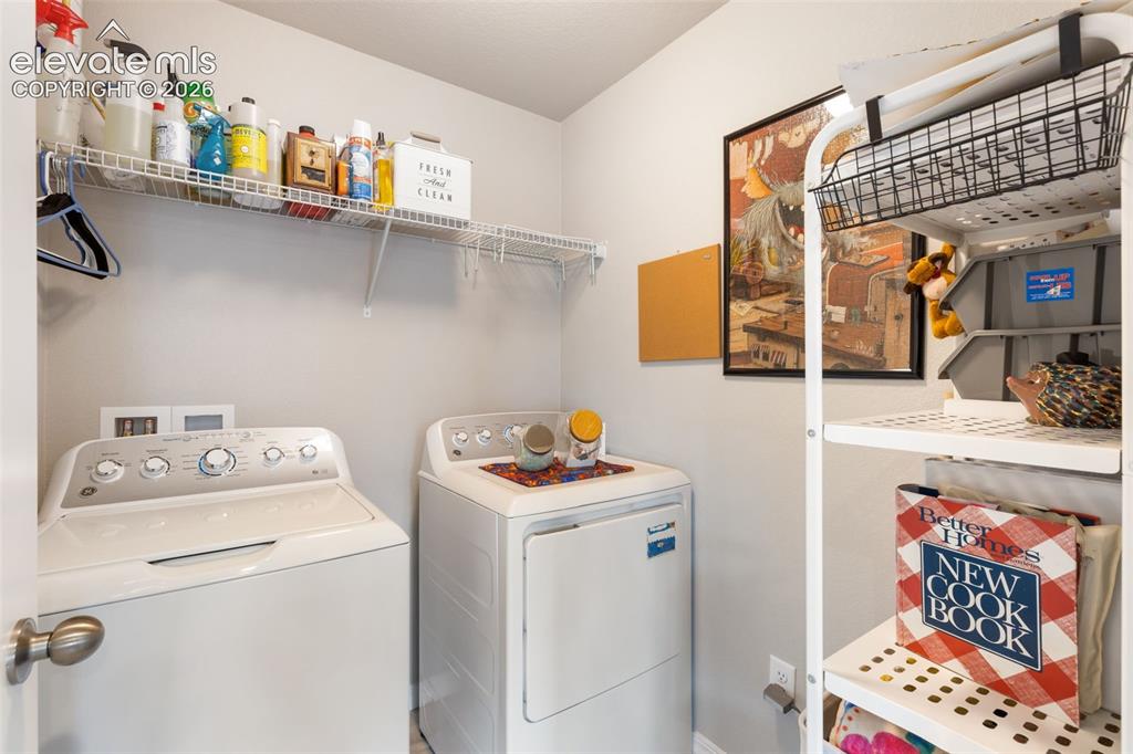 Image 12 of 28: Dedicated laundry area featuring a washer and dryer, integrated wire shelvi