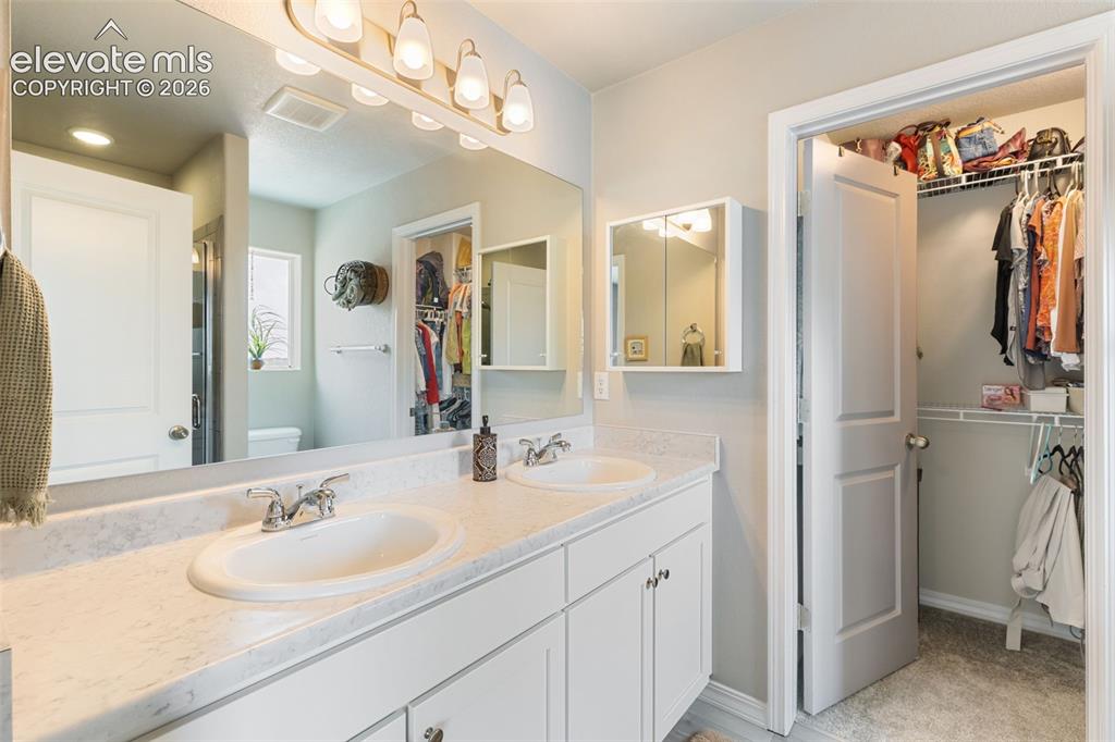 Image 15 of 28: Double vanity featuring integrated sinks, chrome faucets, and a light-toned