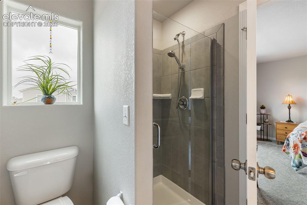 Image 16 of 28: Bathroom featuring a walk-in shower with glass enclosure, gray tile surroun