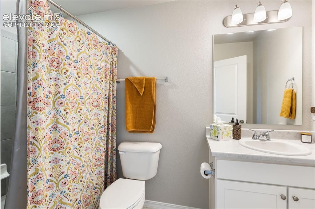 Image 19 of 28: Bathroom featuring a single vanity with an integrated sink, polished chrome