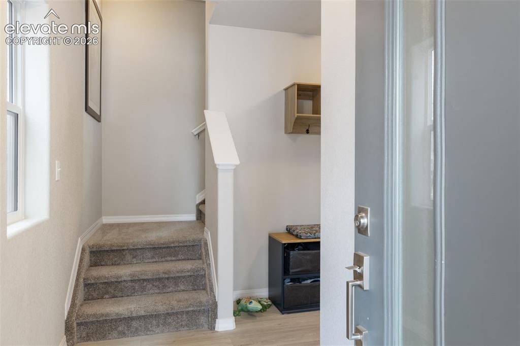 Image 3 of 28: Entryway featuring light wood-finish flooring, a contemporary gray door wit