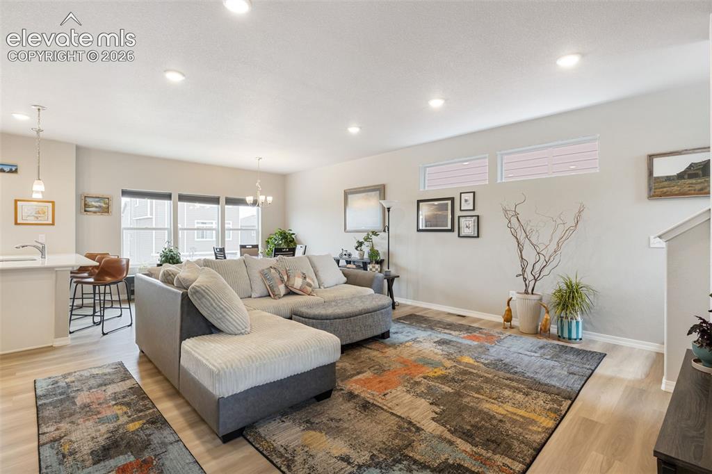 Image 5 of 28: Open-concept living area with recessed lighting and wood-finish flooring