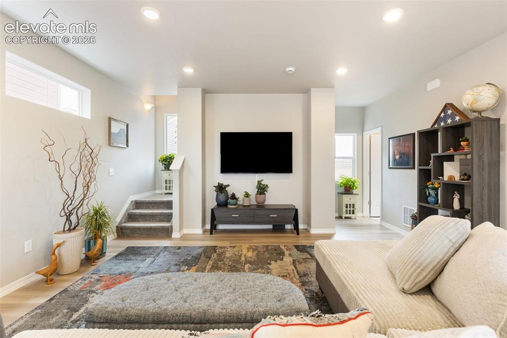 Image 6 of 28: Spacious living area featuring light-toned walls, recessed lighting, and wo