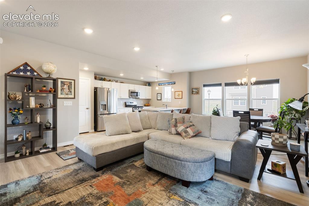 Image 8 of 28: Open-concept living space featuring recessed lighting and wood-finish floor