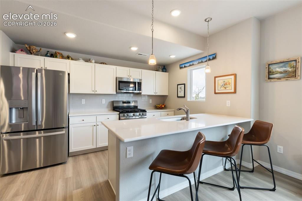 Image 9 of 28: Modern kitchen featuring white shaker cabinetry, stainless steel appliances