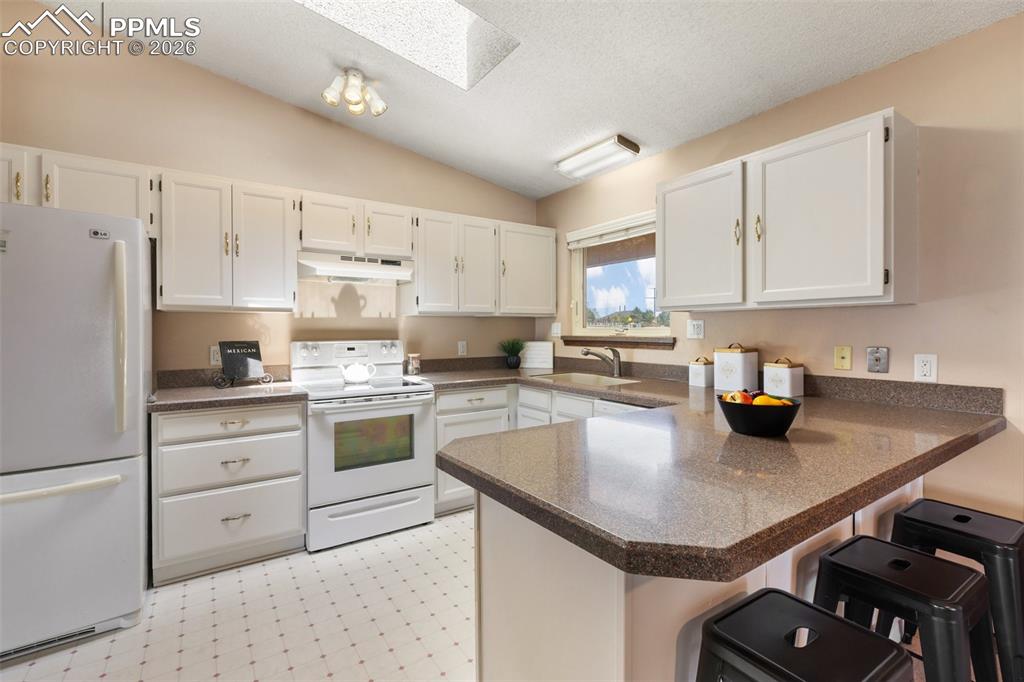 Image 22 of 50: Kitchen features granite transformation countertop and skylight - easy to e