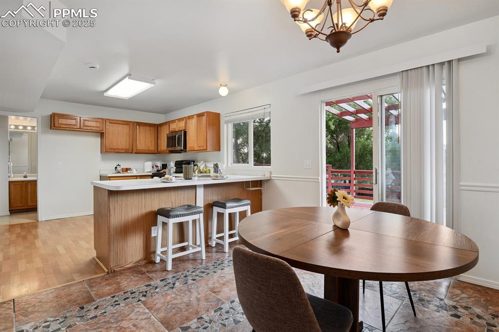 Image 11 of 45: Dining space featuring a chandelier and light stone finish flooring