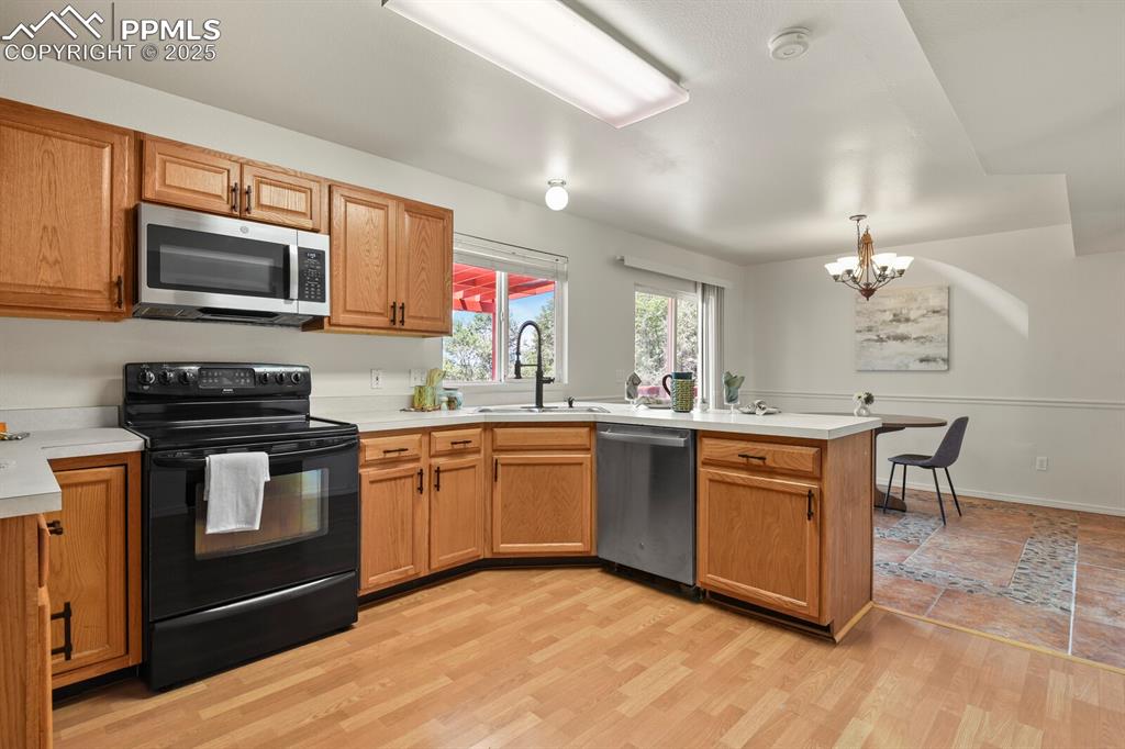Image 13 of 45: Kitchen featuring appliances with stainless steel finishes, a peninsula, a 
