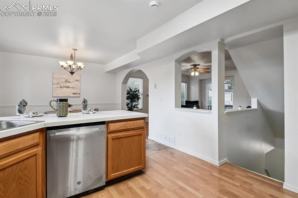 Image 15 of 45: Kitchen with dishwasher, ceiling fan, light countertops, a chandelier, and 