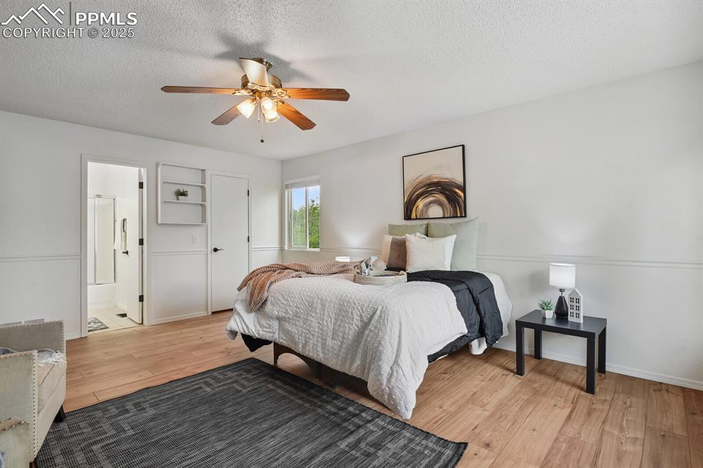 Image 18 of 45: Bedroom with light wood-style flooring, a textured ceiling, a ceiling fan, 
