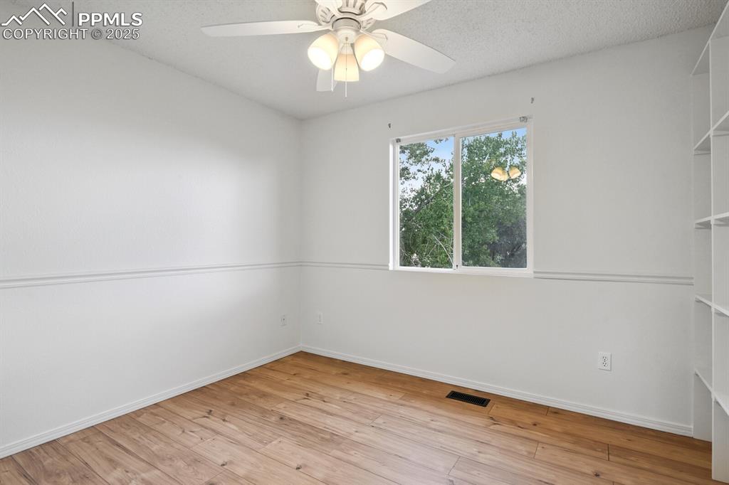 Image 22 of 45: Spare room featuring light wood finished floors and ceiling fan