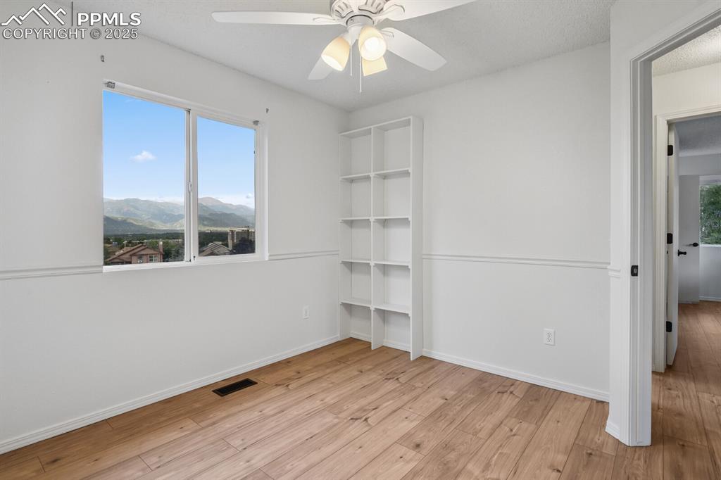 Image 24 of 45: Unfurnished bedroom with light wood-style floors, multiple windows, a mount
