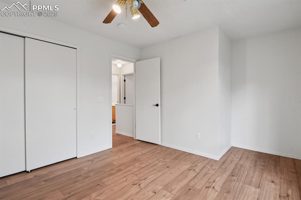 Image 28 of 45: Unfurnished bedroom with light wood-style floors, a closet, and ceiling fan
