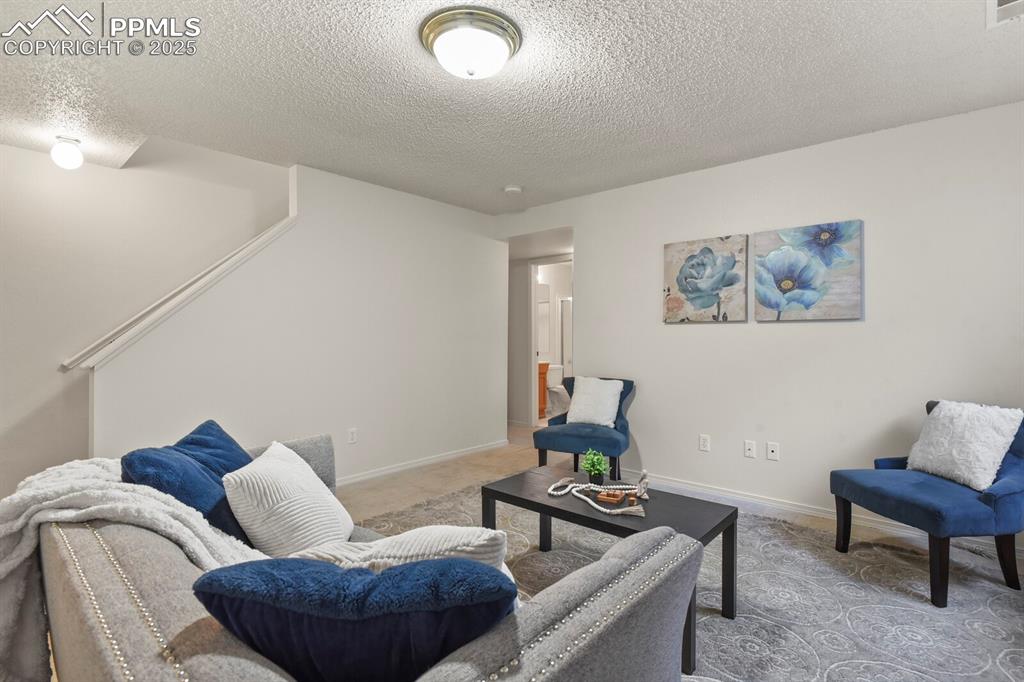 Image 30 of 45: Living room featuring a textured ceiling and carpet flooring