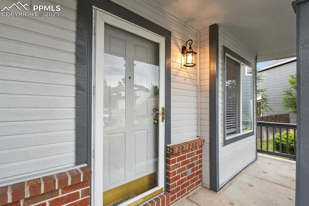 Image 4 of 45: Entrance to property featuring covered porch and brick siding