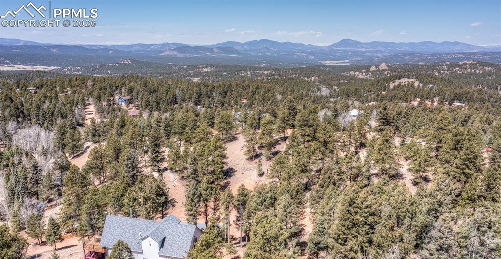 Image 15 of 21: Drone / aerial view of mountains and a heavily wooded area