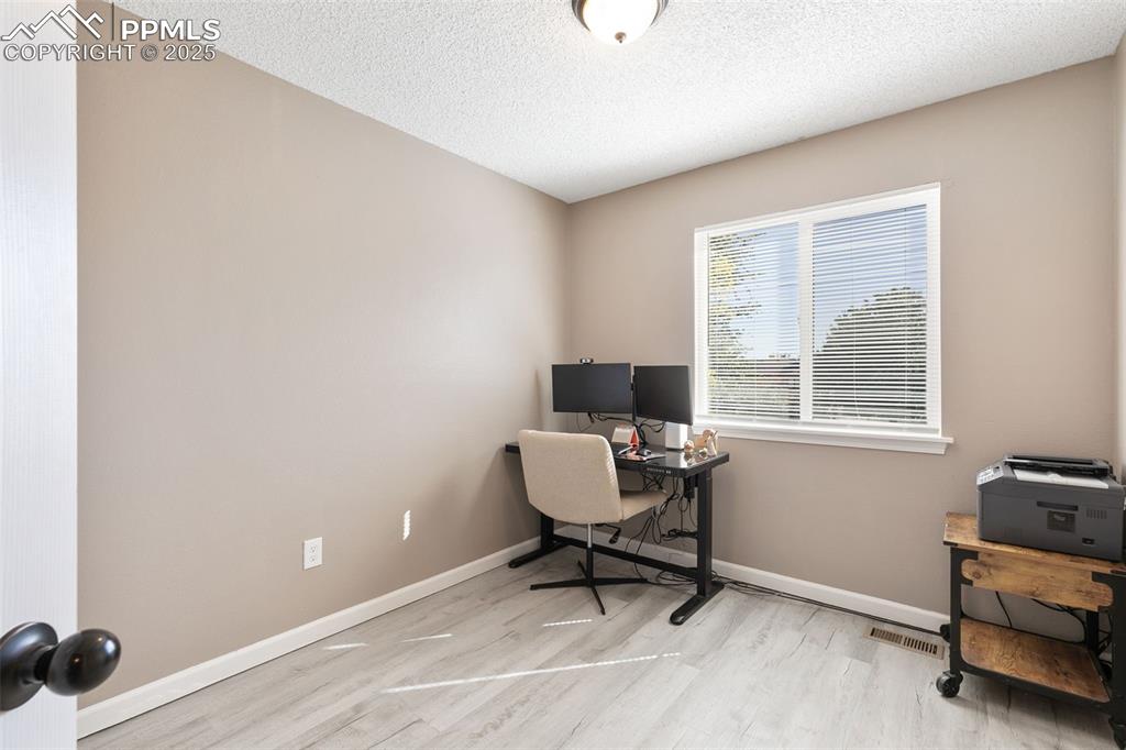 Image 26 of 29: Home office featuring a textured ceiling and light wood-type flooring