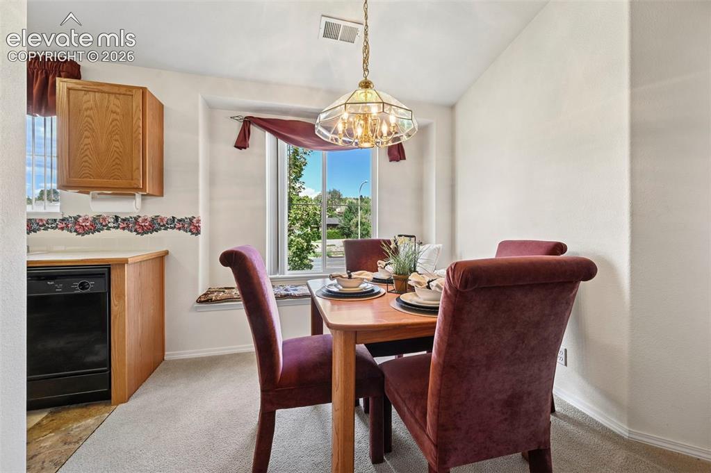 Image 12 of 48: Dining room with bay window seating and mountain views