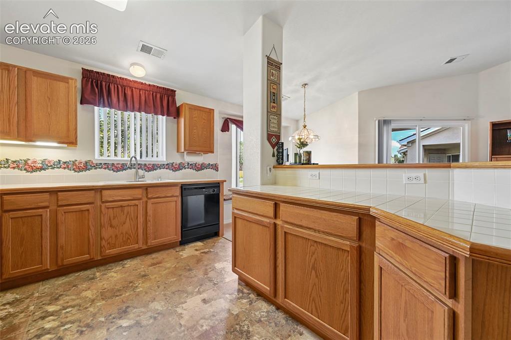 Image 8 of 48: large open kitchen with breakfast bar overlooking diningand living rooms