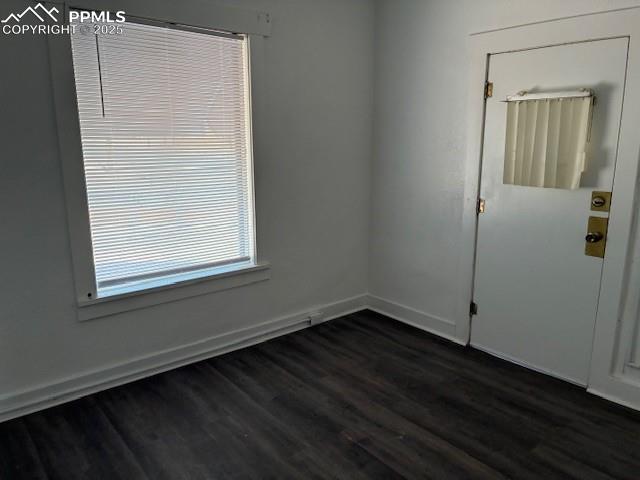 Image 4 of 13: Empty room featuring dark wood-style flooring and baseboards