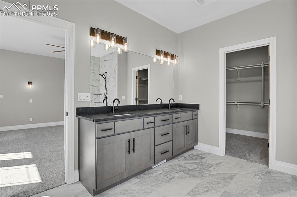 Image 19 of 44: Double vanity and view of walk-in closet