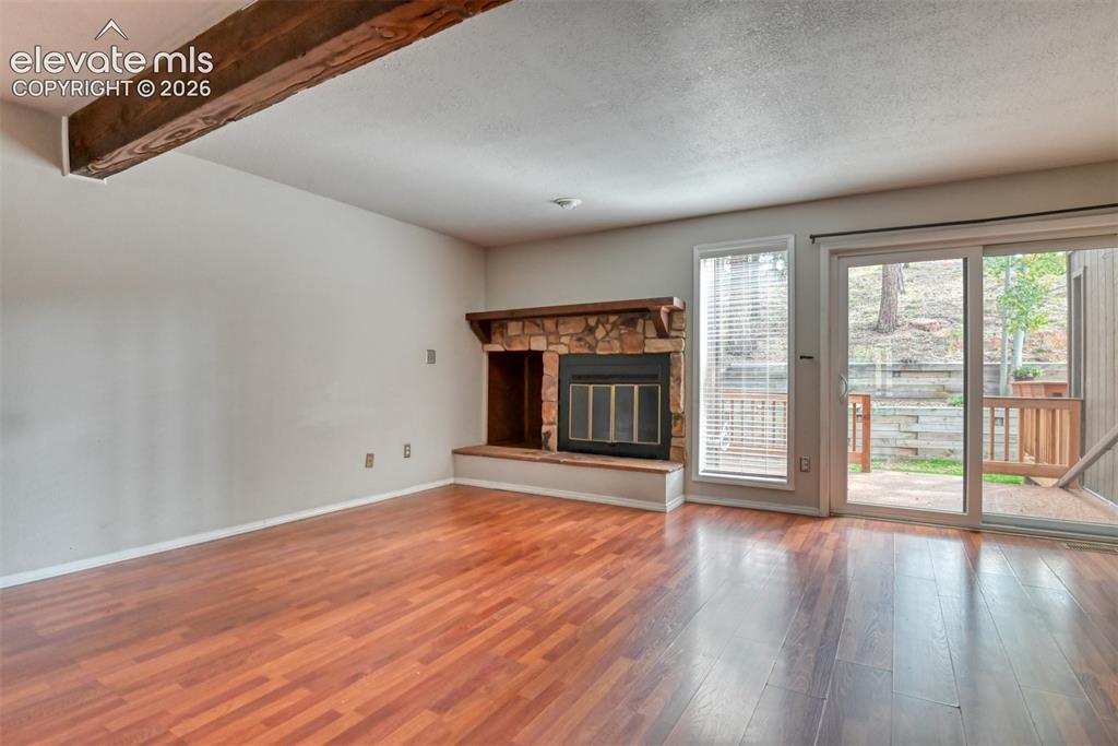 Image 16 of 50: Wood-finish flooring throughout, stone-clad fireplace with wood mantel, exp
