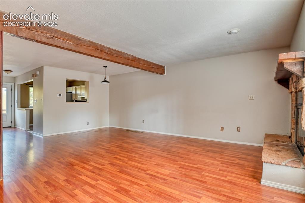 Image 18 of 50: Wood-finish flooring with an exposed wood beam