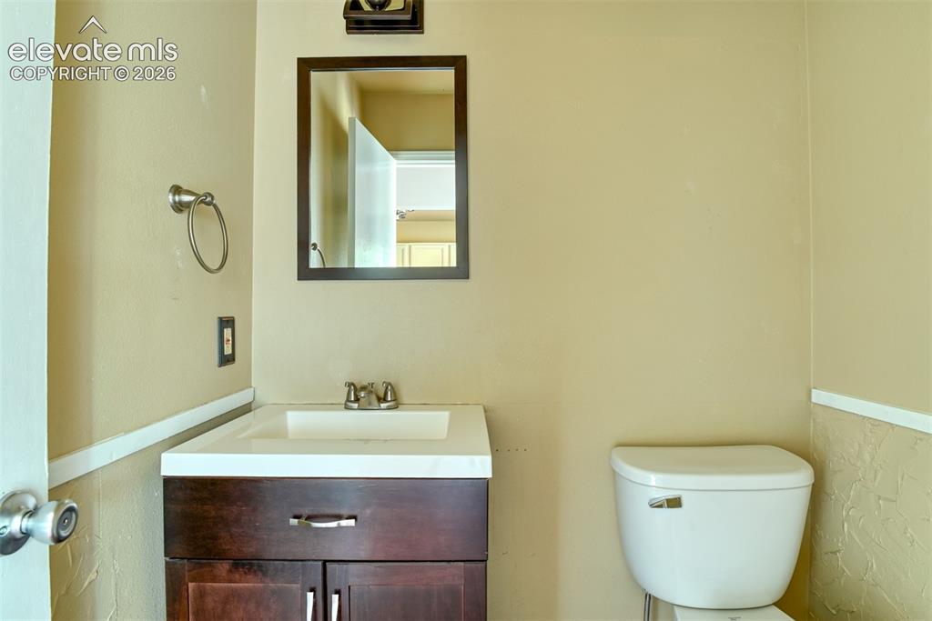 Image 19 of 50: Dark wood-finish vanity with integrated sink, chrome faucet, and rectangula