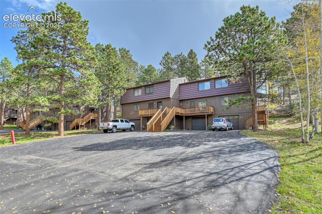 Image 2 of 50: Multi-level exterior with dark siding and a brown metal roof