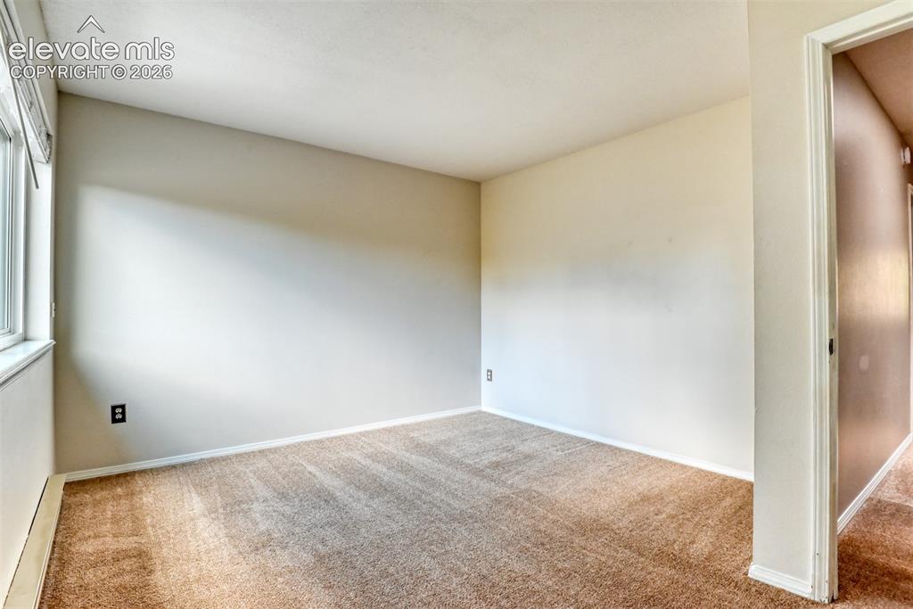 Image 23 of 50: Carpeted room with a white window frame, light-colored walls, and a white c