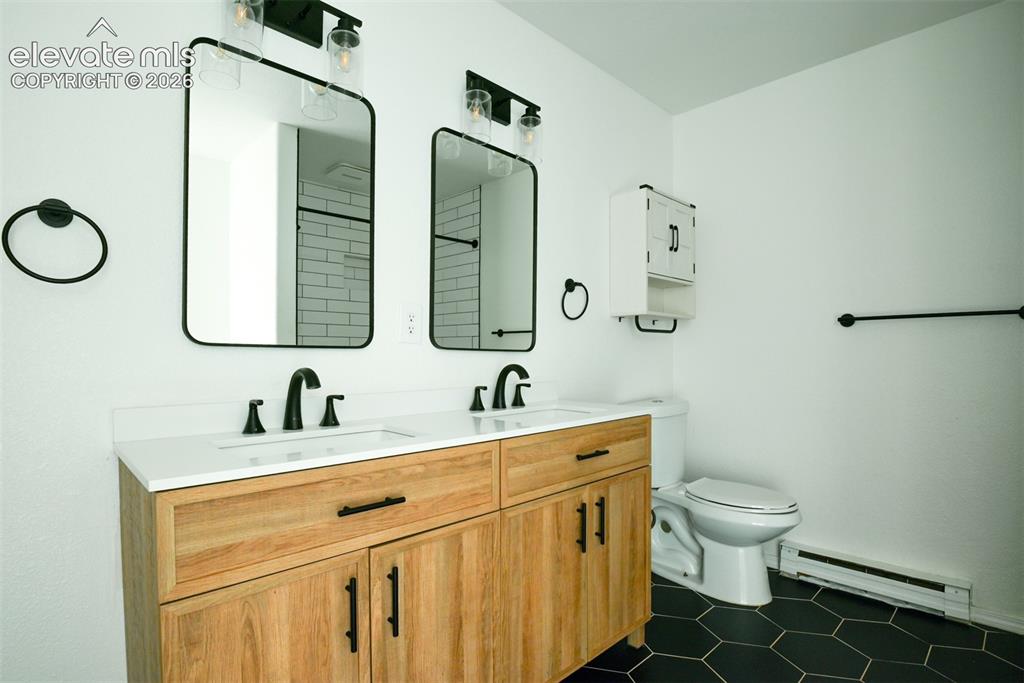 Image 26 of 50: Dual vanity with wood-finish cabinetry and matte black hardware