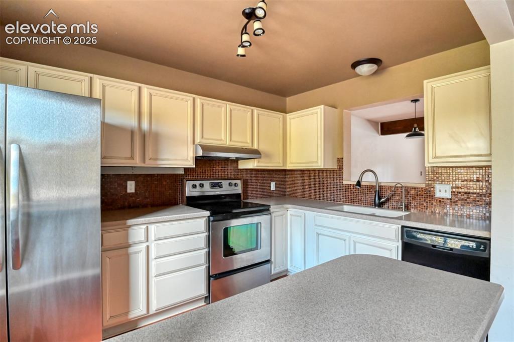 Image 7 of 50: Kitchen featuring stainless steel appliances, light-toned cabinetry, mosaic