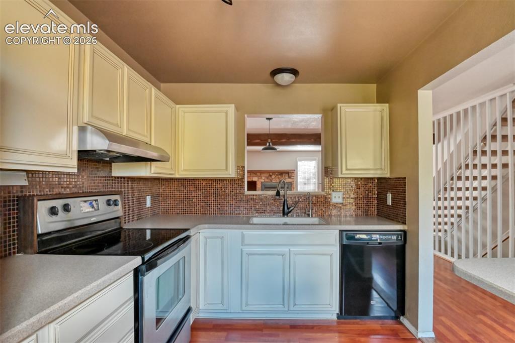 Image 9 of 50: Kitchen featuring light-toned cabinetry, a mosaic tile backsplash, a stainl