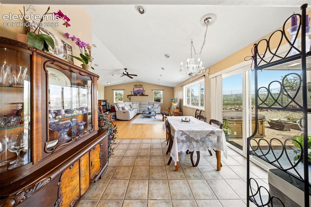 Image 10 of 40: Spacious open-concept living area featuring a formal dining space with a ch