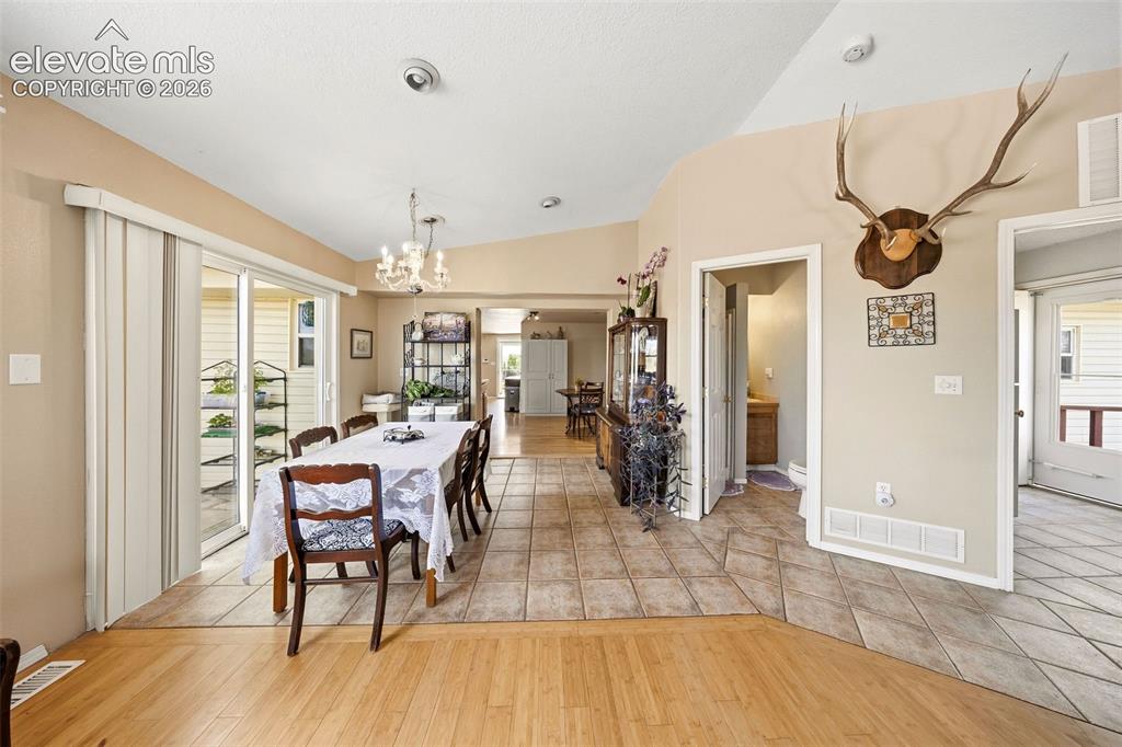 Image 14 of 40: Dining area with vaulted ceilings and a chandelier lighting fixture