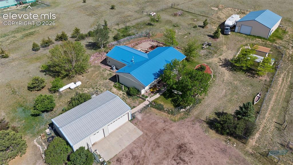 Image 2 of 40: Expansive property featuring a main residence with a blue metal roof, a det