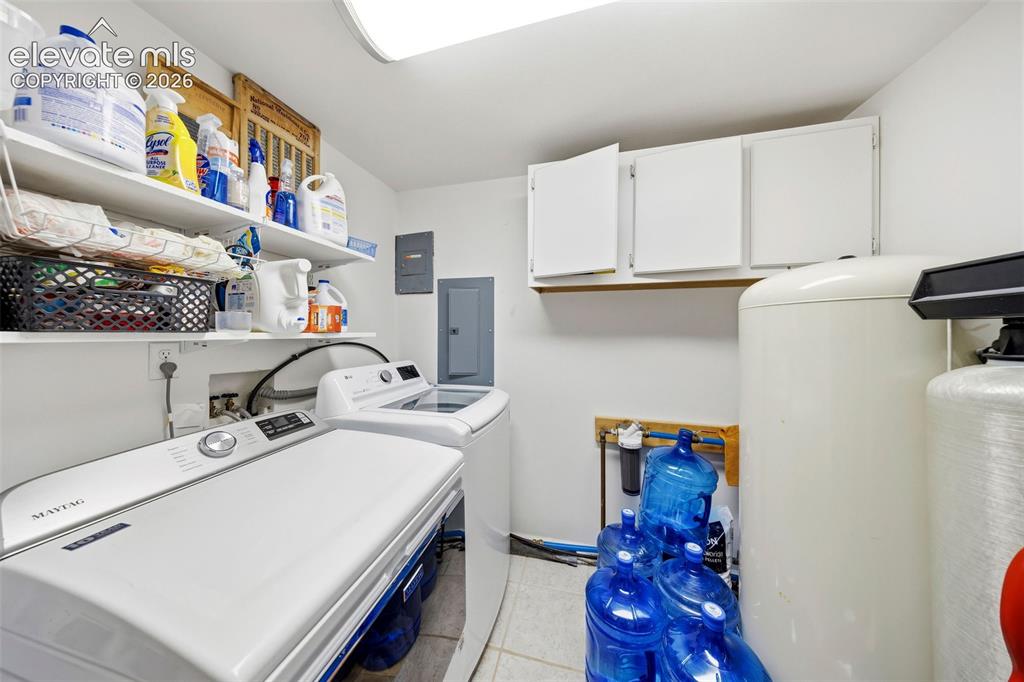 Image 26 of 40: Dedicated laundry area featuring a washing machine and dryer, white wall-mo