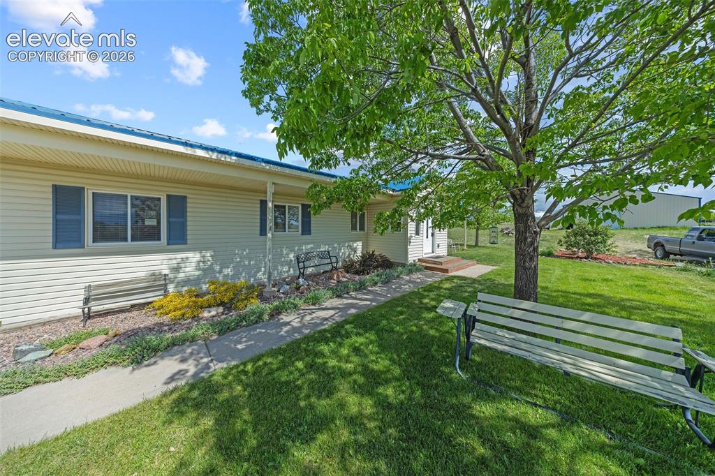 Image 28 of 40: Front of house with bench to enjoy beautiful front range views.