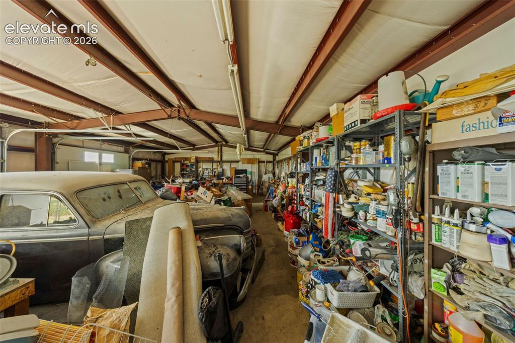Image 29 of 40: Expansive interior garage space featuring exposed steel beams and ample ove