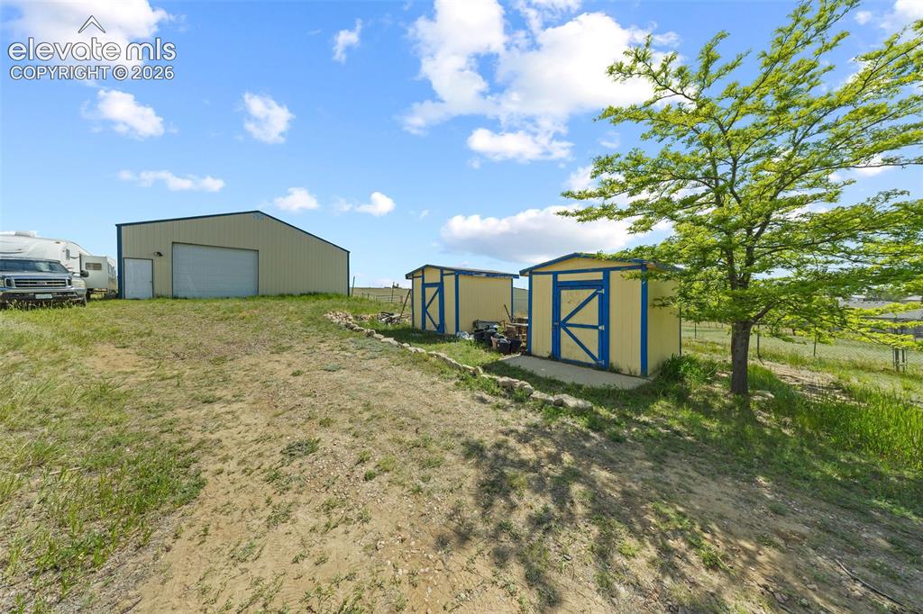 Image 30 of 40: Metal-sided barn featuring large pull-through garage doors and personnel do