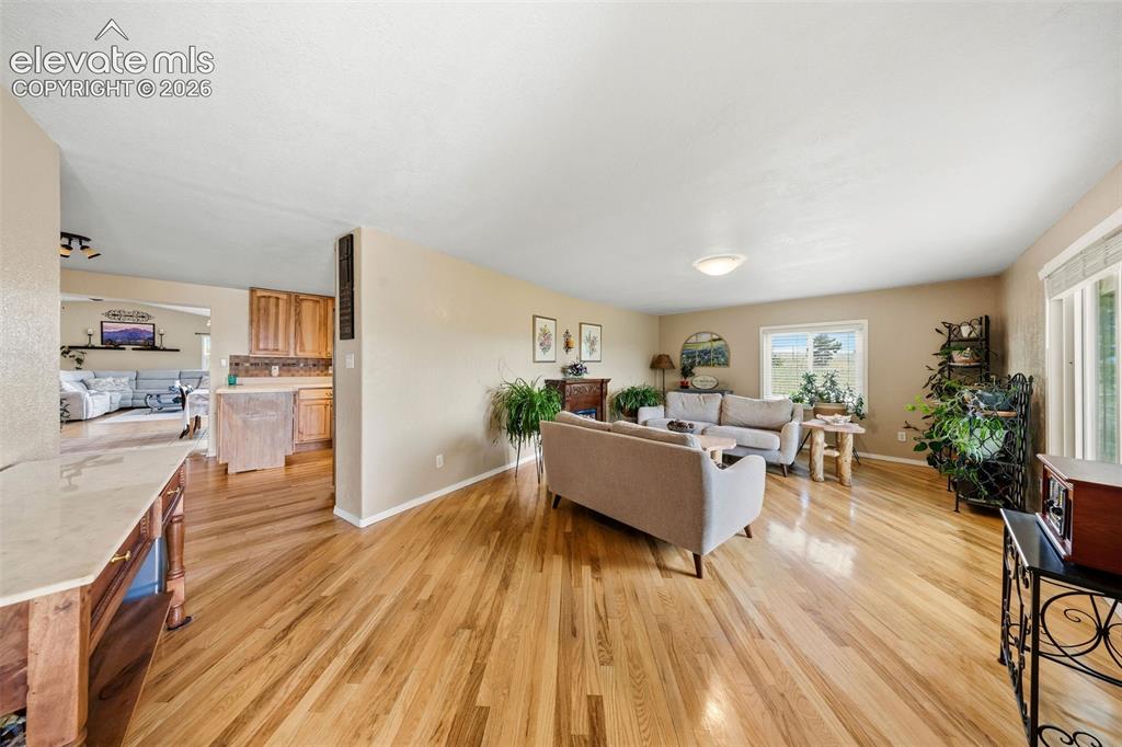 Image 4 of 40: Spacious living area featuring light wood-finish flooring and ample natural