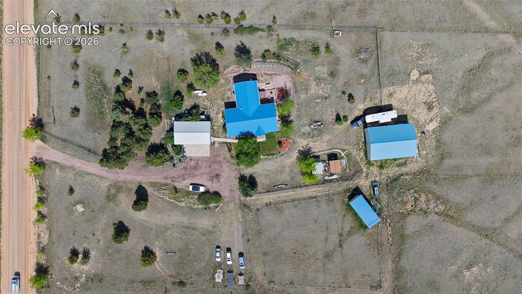 Image 40 of 40: Aerial view showing main house, 4 car garage, horse stalls/tack room, 2 sto